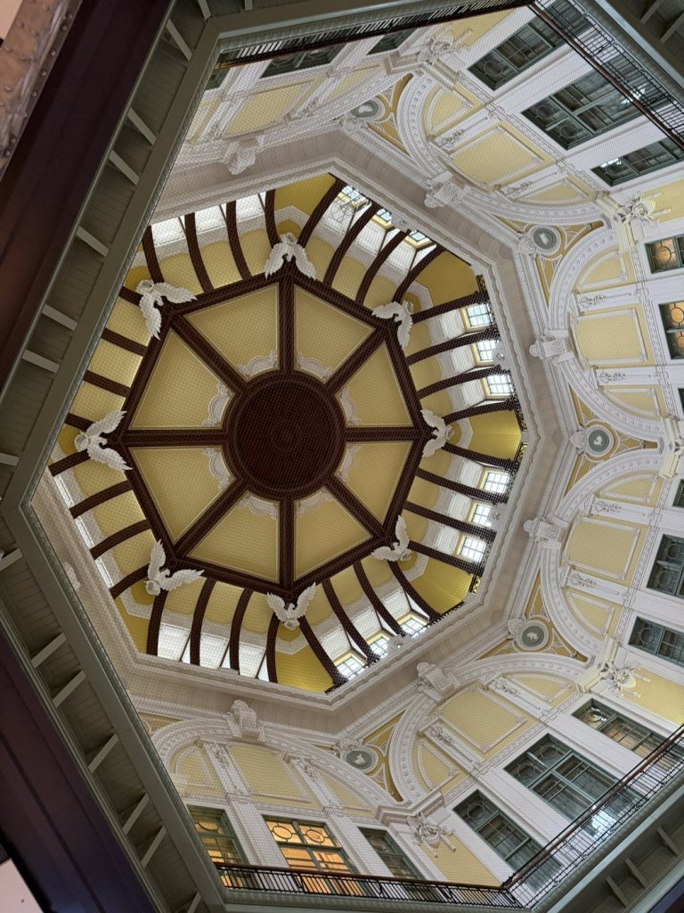 The restored dome ceiling inside the Tokyo Station Marunouchi building, with yellow panels and eagle reliefs